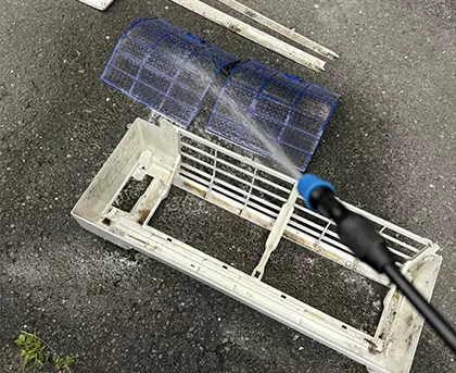 Nettoyage des filtres d’un climatiseur mural lors d’un entretien complet